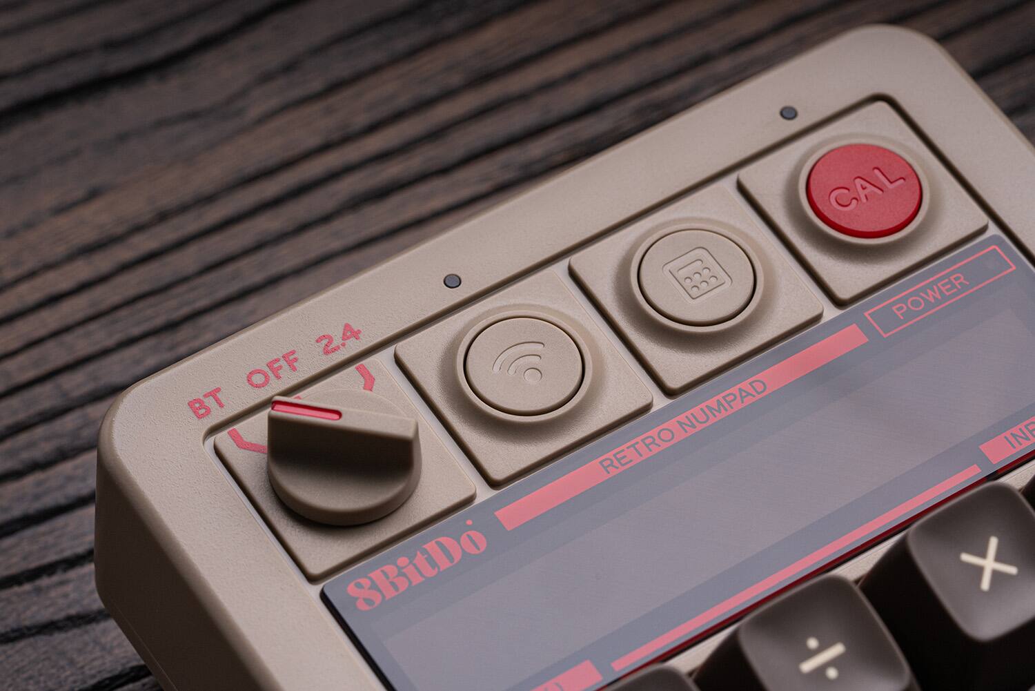 The text on the image is:

CAL POWER 2.4 OFF 1 BT NUMPAD RETRO INF 8BitDo + A %

The corrected text would be:

CAL POWER 2.4 OFF 1 BT NUMPAD RETRO INF 8BitDo + A %