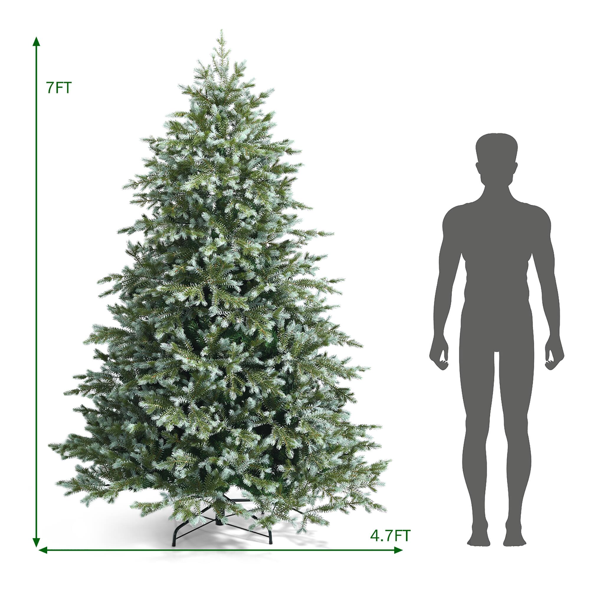 The image shows a large green Christmas tree next to a man's silhouette. The tree is approximately 7 feet tall, and the man's height is approximately 4.7 feet tall.