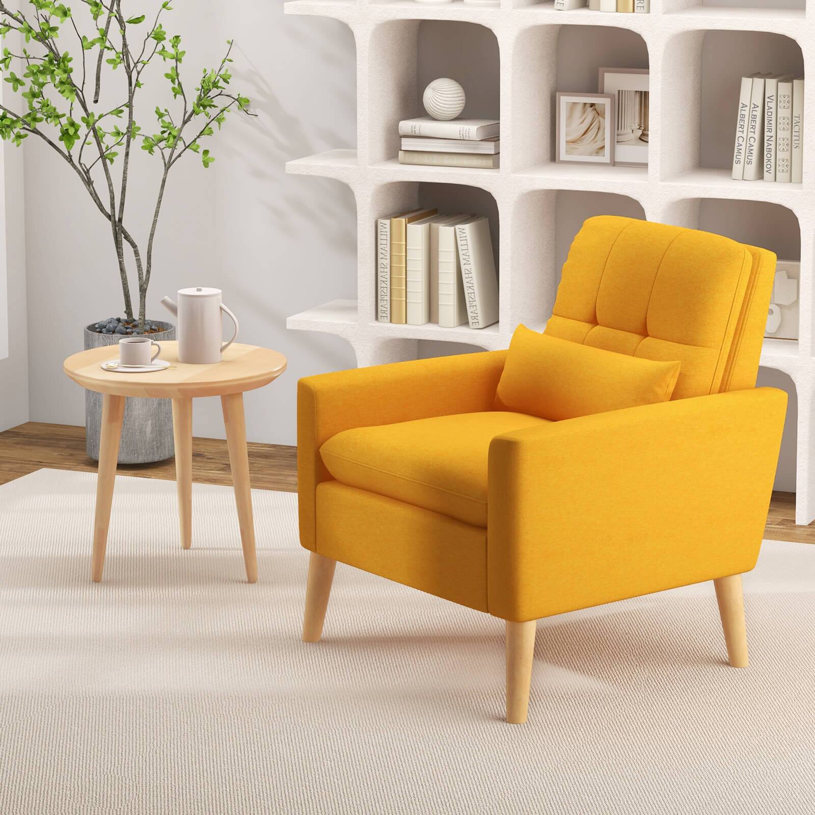 The image features a yellow chair with a wooden frame and a wooden table. The chair is placed on a white carpet, and there is a plant nearby. The room also contains a bookshelf with several books on it, including a collection of Shakespeare's works. The books are arranged in a way that they are visible and easily accessible. The overall setting appears to be a cozy and comfortable living space.