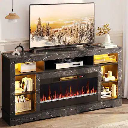 "A flat screen TV is sitting on a black entertainment center with a fireplace underneath. The TV is turned on and displaying a snowy scene. The entertainment center also has a bookshelf with several books on it. There is a vase on the right side of the TV and a potted plant on the left side. The room also has a fireplace, adding warmth and ambiance to the space."