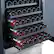 The image shows a wine refrigerator with three shelves filled with wine bottles. The bottles are arranged in rows, with some bottles being red and others being clear. The refrigerator is designed to store and preserve wine, providing a controlled environment for the wine to age and develop its flavors. The wine bottles are organized neatly, making it easy to find and access the desired bottle.