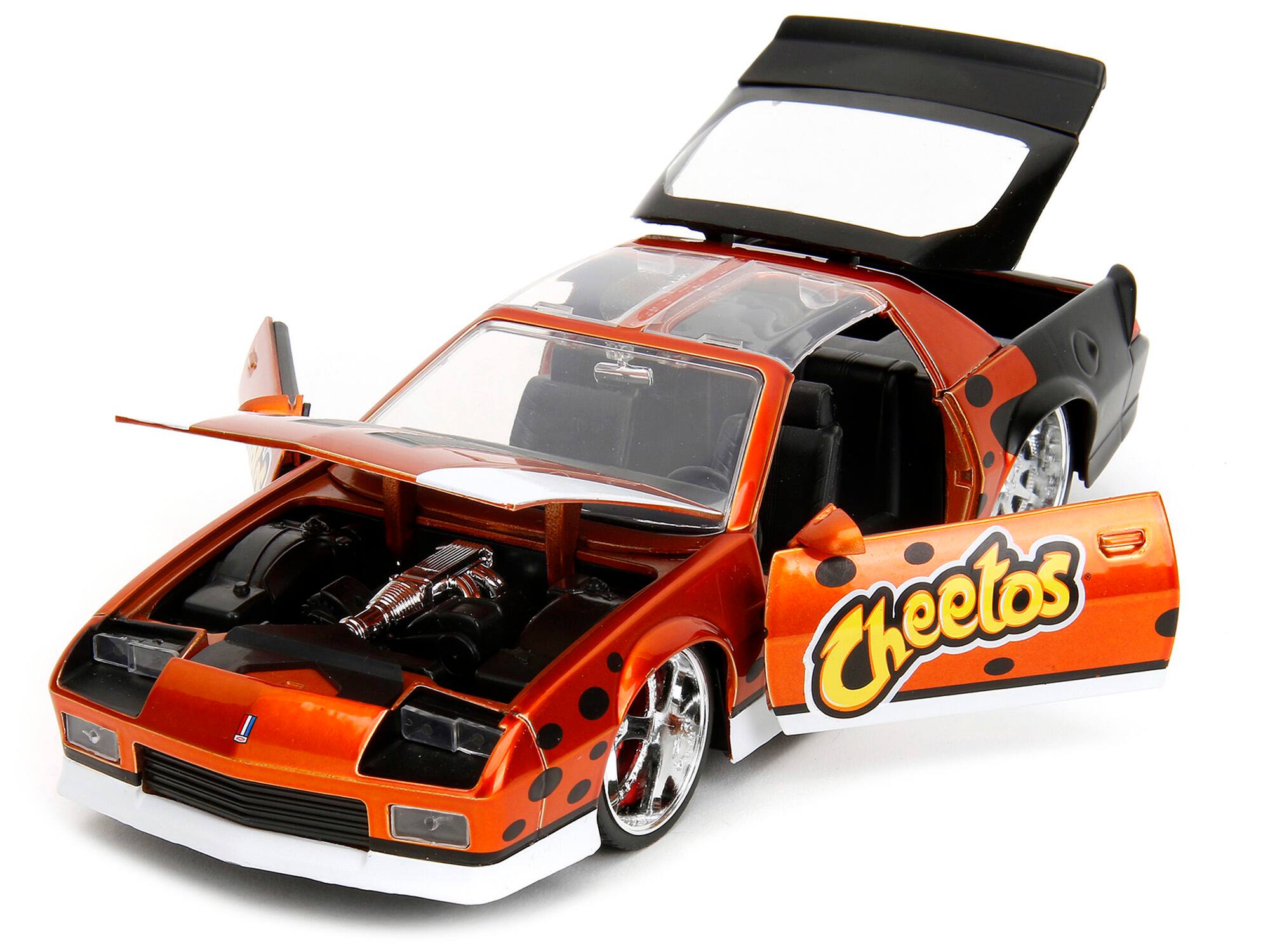 Angle. Jada - 1985 Chevrolet Camaro Z/28 1/24 Diecast Orange Metallic with Graphics & Chester Cheetah Figure "Cheetos" Series - Orange Metallic.