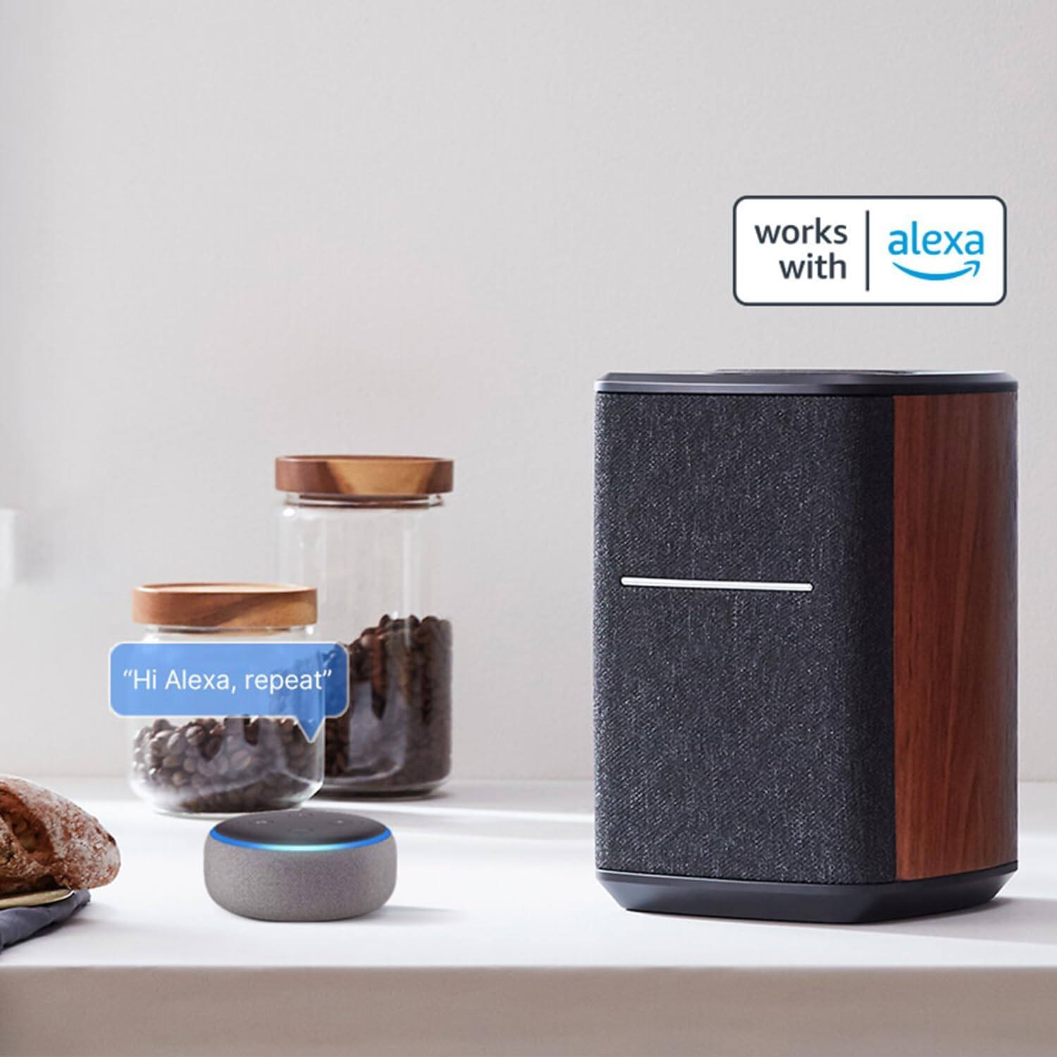 The text on the image reads, "Hi Alexa, repeat." This indicates that the speaker is designed to work with Alexa and can be used to repeat certain phrases or commands.