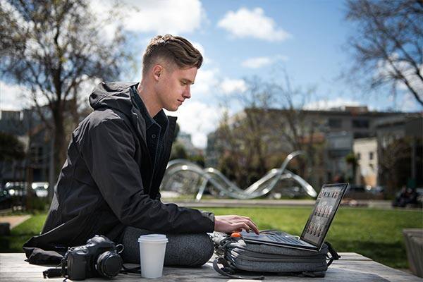 Laptop and digital camera on park table