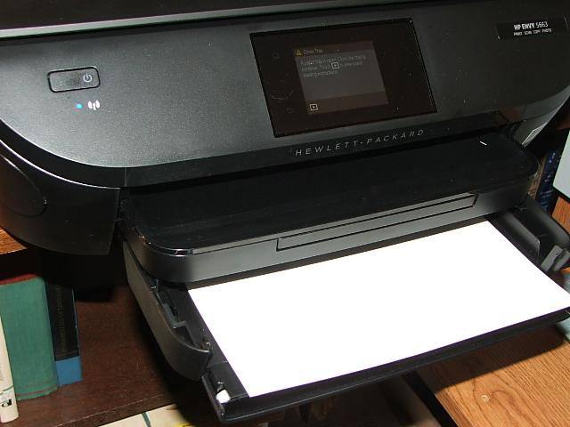 The tray’s front folds down to accommodate 14” paper. The compartment above the tray has a pop-out that holds the printed sheets from falling. Note cover is closed on the memory card slot., click to load a larger version