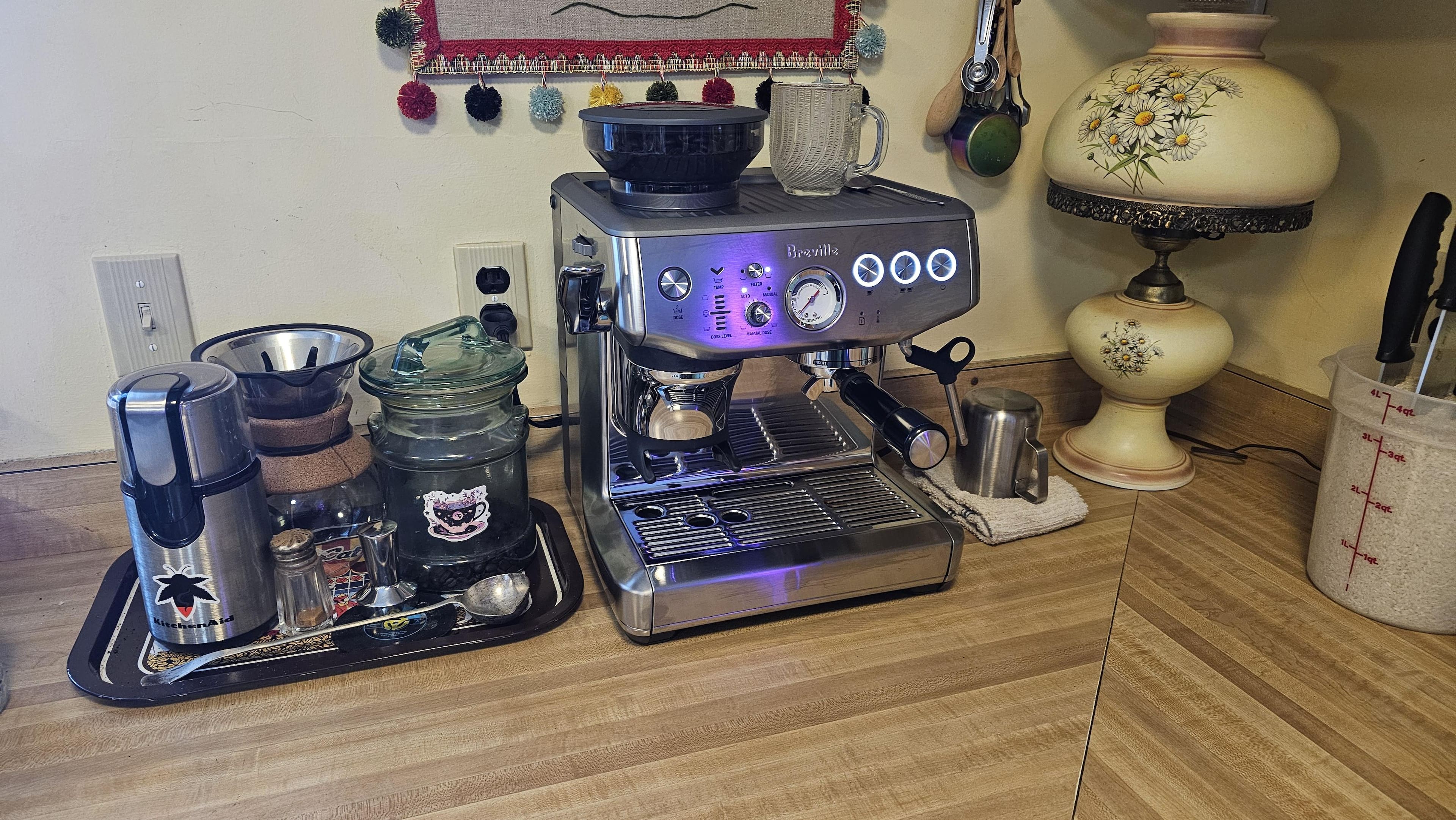 Breville Barista Express Impress in a full owner station with beans, cups and drink ingredients