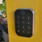 Exterior touch keypad (key-less version). The Yale logo is the one-touch lock area. The keypad has 10 numerals, a settings gear icon, and check button., click to load a larger version