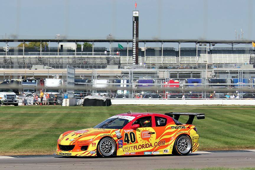 I was 10 yards from a fence, shooting through a 12 inch hole. You can see a little bit of the shadow of the fence in this shot, but the car stayed in great focus as I panned with it., click to load a larger version