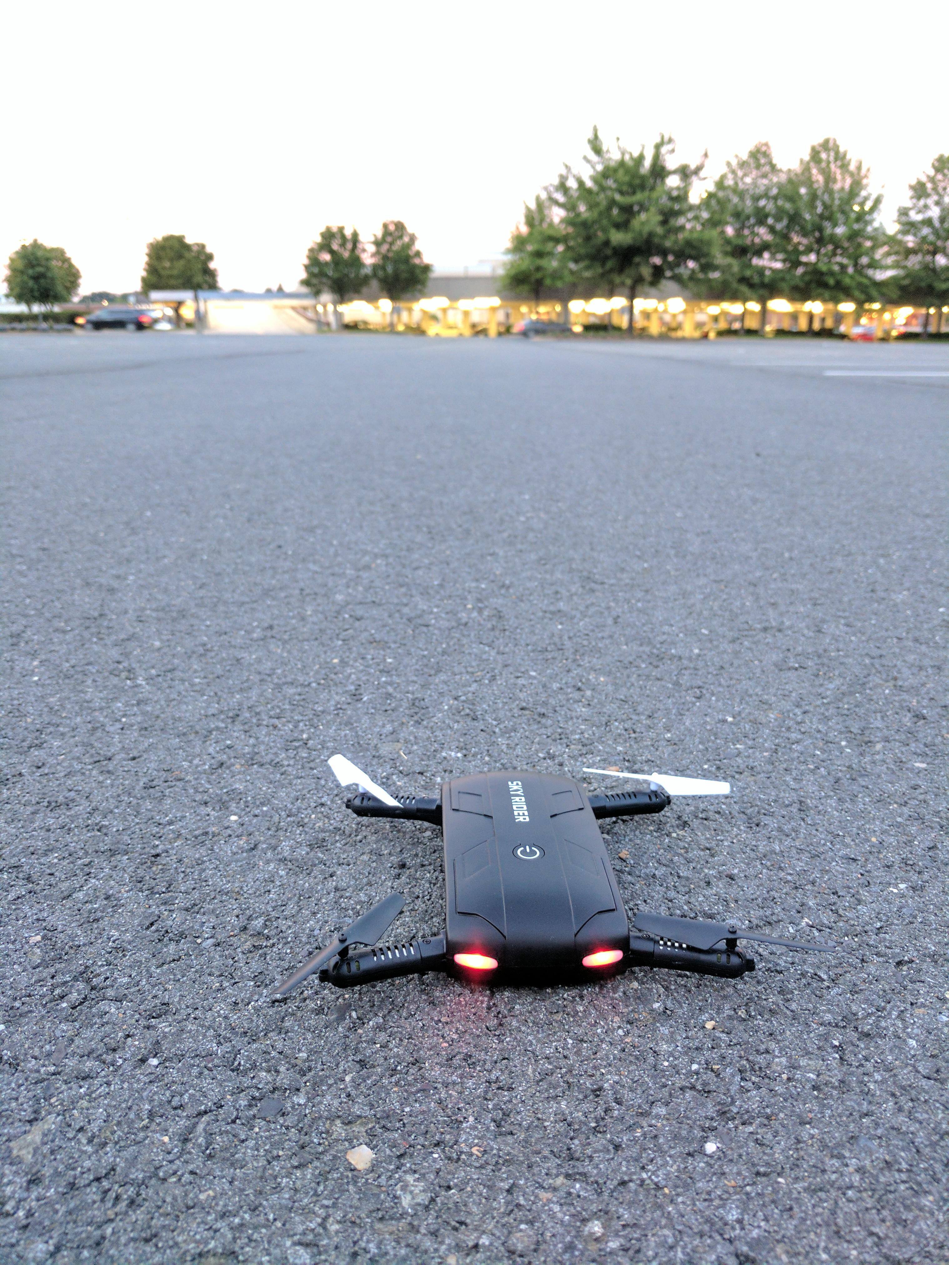 Drone powered on in an empty parking lot., click to load a larger version