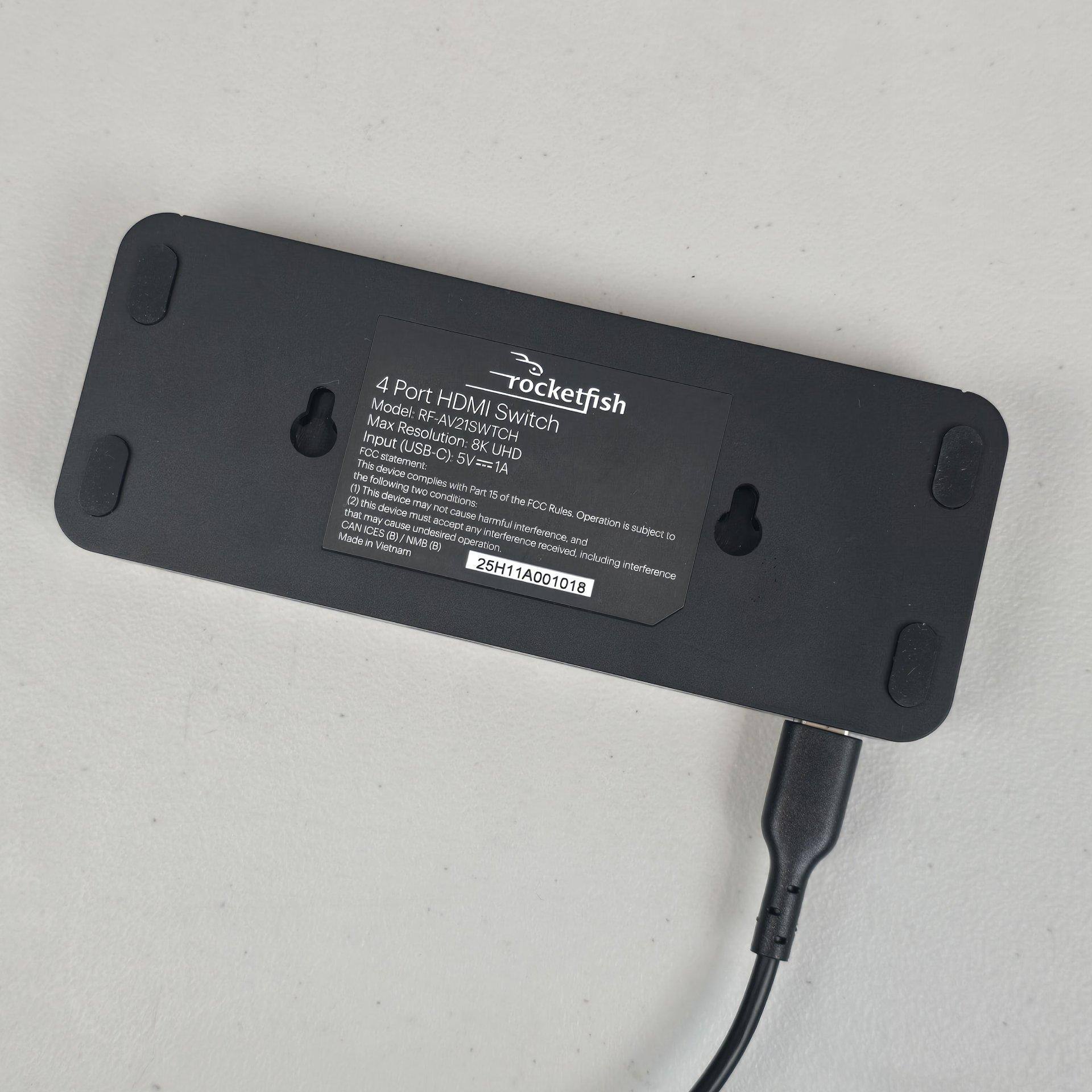 Underside of the switch with rubber feet in each corner and two keyhole slots for hanging on a wall, click to load a larger version