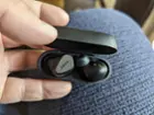 Ear buds in charging case, one flipped so you can see the shape of it., click to load a larger version