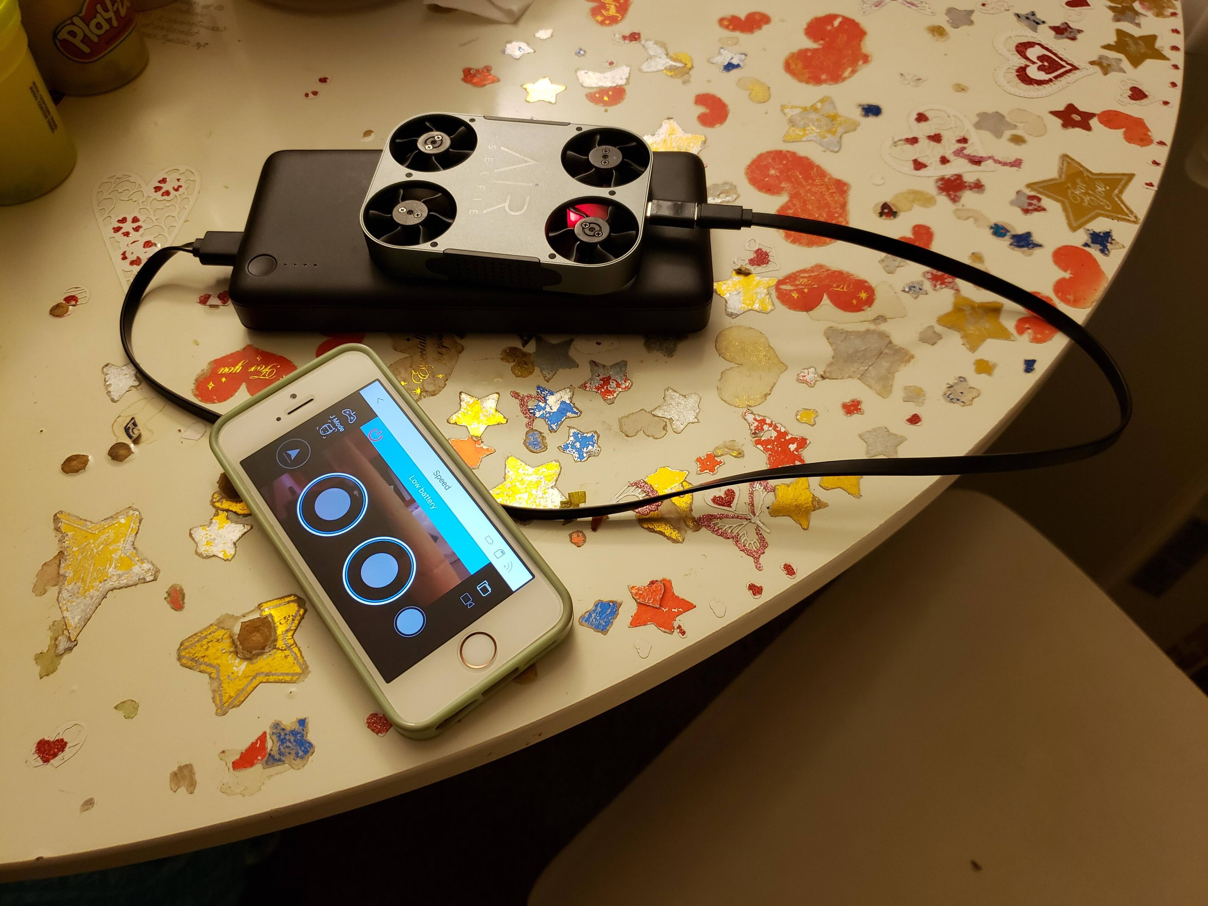 AirSelfie 2 being charged by my powerbank. iPhone SE nearby., click to load a larger version