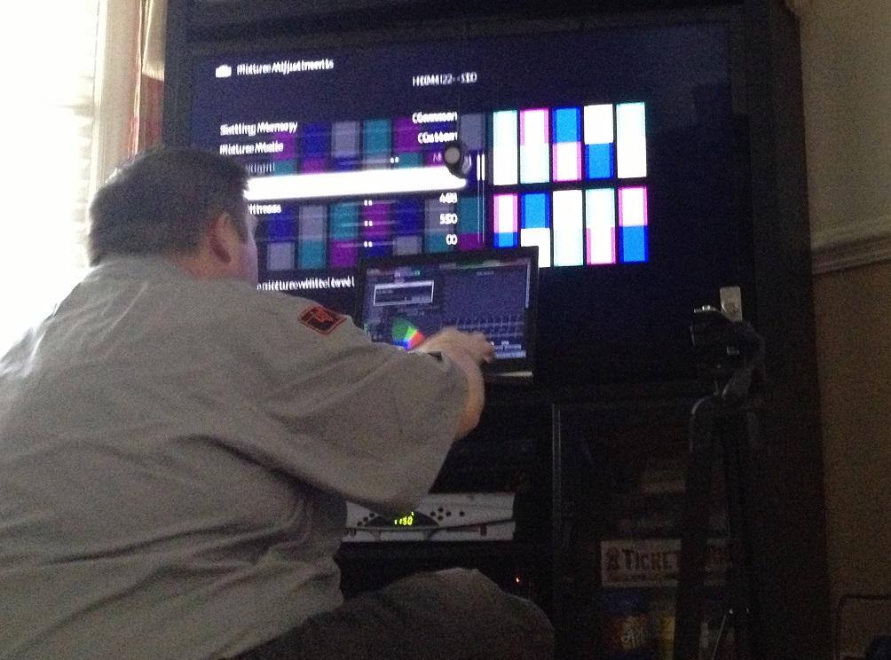 Geek squad agent with test patterns on TV and his laptop computer, click to load a larger version