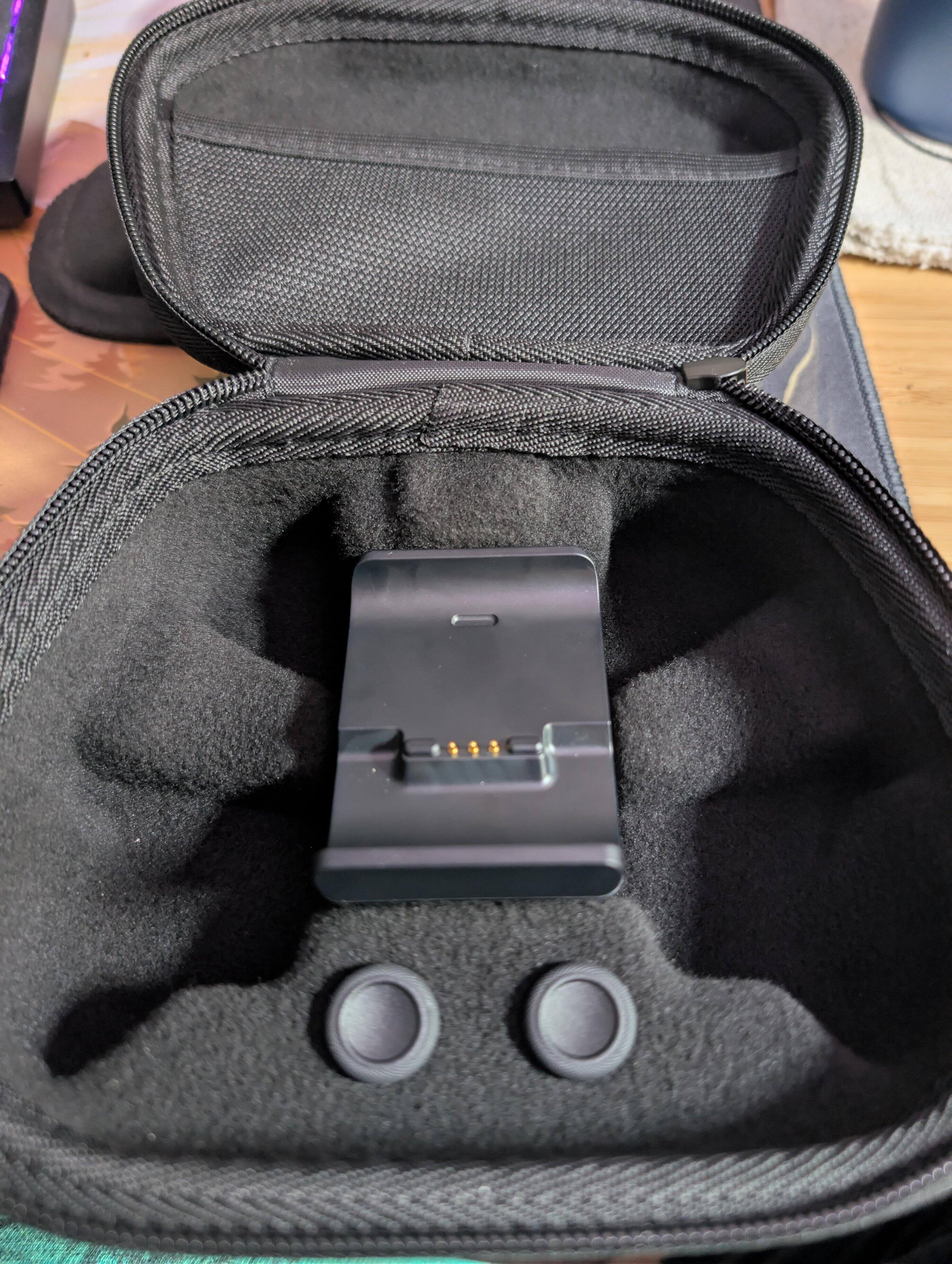 The travel case with the charge dock inside, along with extra, longer thumbsticks. You can charge while in the travel case via a port for the USB cable on the back., click to load a larger version
