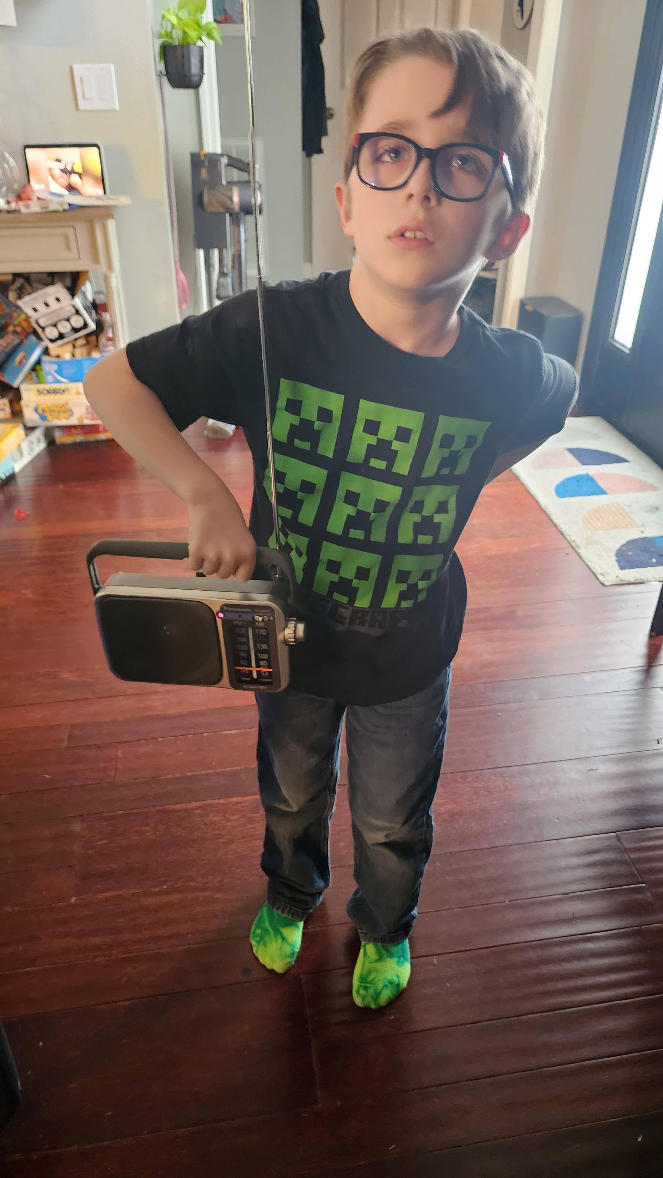 He was not enthusiastic about me snapping this photo, but for a few days he did not put this radio down when walking around the house., click to load a larger version