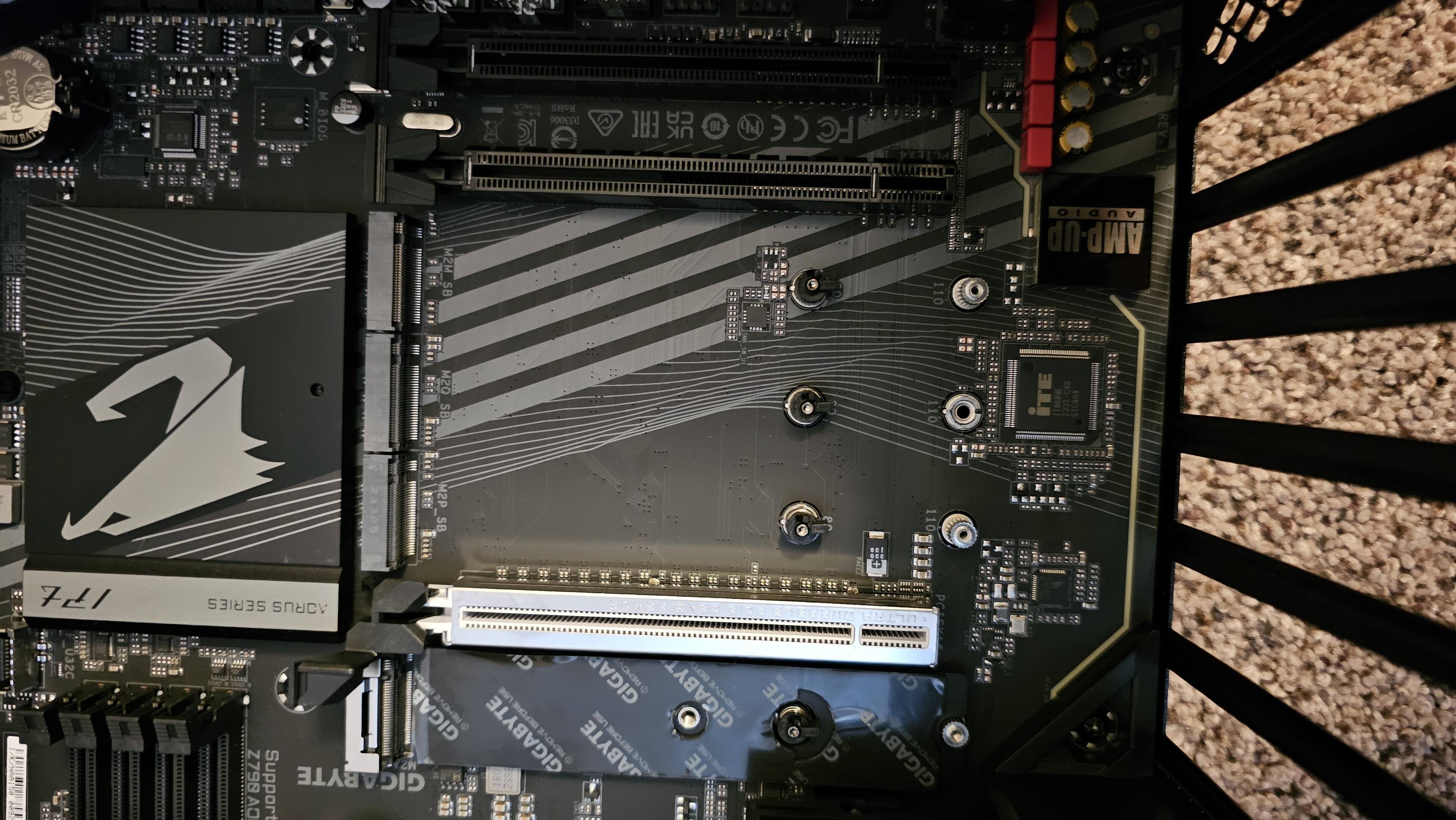 This view, looking "down" the board, shows the uncovered M.2 slots with their EZ-Latch Plus connectors. The PCIe 5.0 x16 slot is in between them, and the audio chip is to the upper right., click to load a larger version