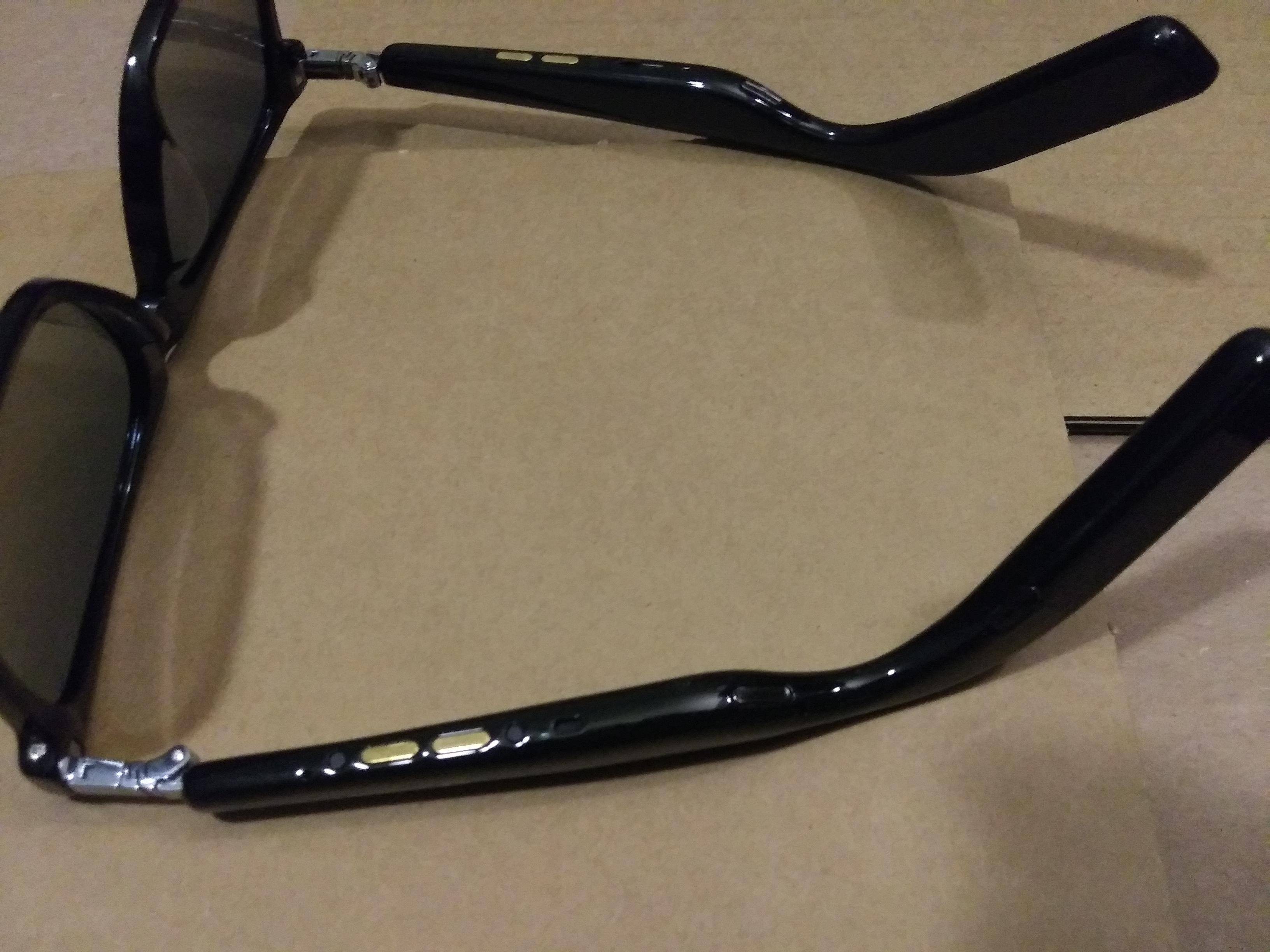 Underside of Sunglasses with gold charging points and Speakers, click to load a larger version