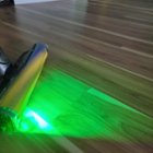 Fluffy Optic cleaner head with green laser highlighting "invisible" dust on the floor in front of the vacuum, click to load a larger version