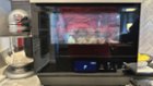 Black HomeCHEF with large glass door & illuminated interior Air Frying chicken., click to load a larger version