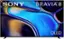 The image features a large Sony Bravia 8 OLED television screen. The screen is displaying a blue and yellow image, which is likely an advertisement or promotional material for the television. The television is mounted on a wall, and the screen occupies a significant portion of the image.